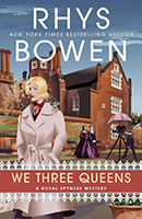 Cover for We Three Queens by Rhys Bowen with a women in a white peacoat and a background of a brown brick building.